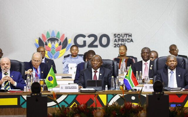 South Africa's President Cyril Ramaphosa (C) speaks alongside Brazil's President Luiz Inacio Lula da Silva (L) and Chairperson of the African Union Joao Lourenco (R) during the G20 Leaders' Summit plenary session at the Nasrec Expo Centre, in Johannesburg on November 22, 2025. (Photo by Thomas Mukoya / POOL / AFP)
