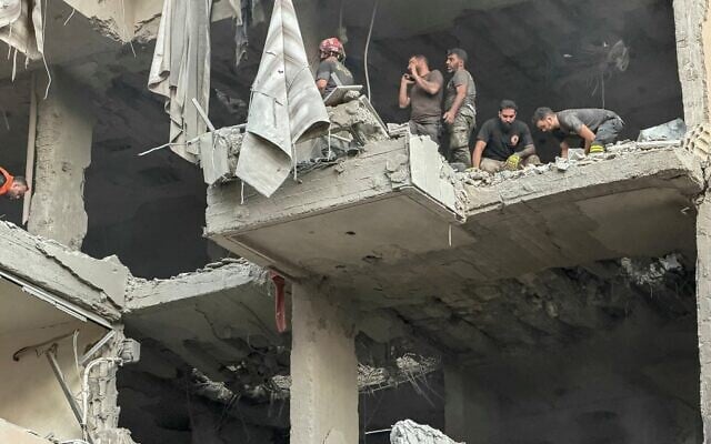 Rescuers search for survivors at the site of an airstrike that Israel said targeted Hezbollah's military chief in a residential building in Beirut's southern Haret Hreik neighborhood on November 23, 2025. (Ibrahim Amro/AFP)