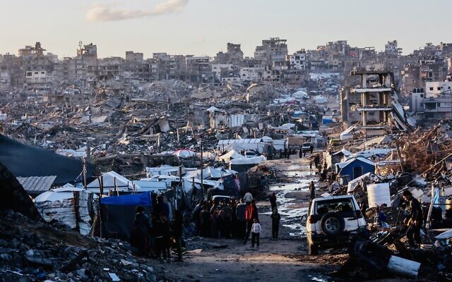 Displaced Palestinians stand on a road after heavy rain in Jabalia, in the northern Gaza Strip, on November 25, 2025. (Omar AL-QATTAA / AFP)
