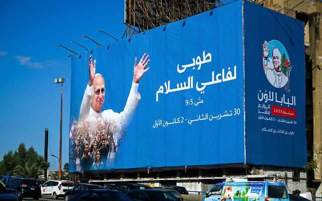 Motorists drive past a billboard displaying a picture of Pope Leo XIV in Beirut on November 26, 2025. (Joseph EID / AFP)