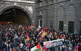 People march behind a banner reading "Against the war maneuver, for wages, pensions and social rights" during an anti-Israel demonstration amid a one-day strike in Genoa, Italy on November 28, 2025 (Piero CRUCIATTI / AFP)
