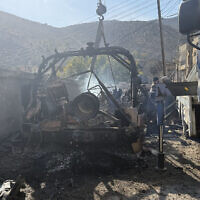 A crane removes a burnt Israeli Humvee from a street in the southern Syrian village of Beit Jinn on November 28, 2025, following a nighttime gun battle (AFP)