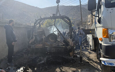 A crane removes a burnt Israeli Humvee from a street in the southern Syrian village of Beit Jinn on November 28, 2025, following a nighttime gun battle (AFP)