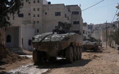 Illustrative: Israeli army vehicles are seen during a military operation in the West Bank city of Jenin, March 11, 2025. (Majdi Mohammed/AP)