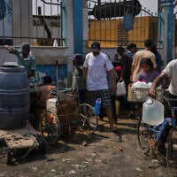 Palestinians collect drinking water at a desalination plant in Deir al-Balah, central Gaza Strip, August 13, 2025. (AP Photo/Abdel Kareem Hana)