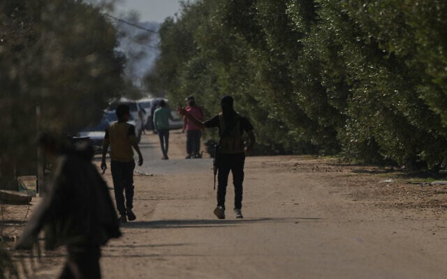 Masked Hamas gunmen take positions in Khan Younis, southern Gaza Strip, ahead of handing over Israeli hostages to the Red Cross, Oct. 13, 2025. (AP Photo/Abdel Kareem Hana)