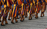 Swiss Guards march prior to the arrival of Britain's King Charles III and Queen Camilla arrive in the St. Damasus Courtyard at the Vatican for a state visit, where they will meet with Pope Leo XIV and pray with him in the Sistine Chapel, October 23, 2025. (AP Photo/ Andrew Medichini)