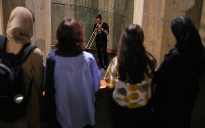 Women watch as a man plays trombone as people listen at the Tehran Museum of Contemporary Art, Iran, Oct. 26, 2025. (AP Photo/Vahid Salemi)