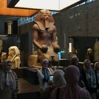 Visitors pose for a group photo under Hatshepsut statue, at the Grand Egyptian Museum in Giza, Egypt, May 23, 2025. (AP Photo/Amr Nabil)