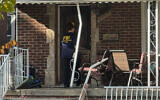 An FBI agent enters a home in a neighborhood of Dearborn, Michigan, on October 31, 2025. (Mike Householder/AP)