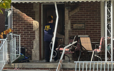 An FBI agent enters a home in a neighborhood of Dearborn, Michigan, on October 31, 2025. (Mike Householder/AP)