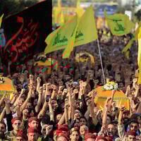 Hezbollah fighters and supporters raise their fists and chant slogans as they march in the funeral procession of five comrades killed in Israeli strikes in recent days, in the southern town of Nabatieh, Lebanon, November 2, 2025. (AP Photo/Mohammad Zaatari)