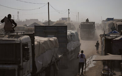 Armed men guard trucks carrying aid as they drive through Khan Younis, southern Gaza Strip, November 2, 2025. (AP Photo/Jehad Alshrafi)