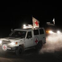 Red Cross vehicles carrying the bodies of three deceased hostages handed over by Hamas make their way toward the border crossing with Israel, in Deir al-Balah, central Gaza Strip, November 2, 2025. (AP Photo/Jehad Alshrafi)