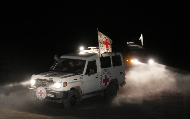 Red Cross vehicles carrying the bodies of three deceased hostages handed over by Hamas make their way toward the border crossing with Israel, in Deir al-Balah, central Gaza Strip, November 2, 2025. (AP Photo/Jehad Alshrafi)
