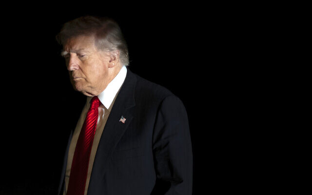 US President Donald Trump is illuminated by a camera flash as he walks across the South Lawn of the White House, in Washington, DC, November 2, 2025. (AP Photo/Mark Schiefelbein) US President Donald Trump is illuminated by a camera flash as he walks across the South Lawn of the White House, in Washington, DC, November 2, 2025. (AP Photo/Mark Schiefelbein)