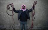 A man shows two ropes tied in the shape of nooses, found in the infamous Saydnaya military prison, just north of Damascus, Syria, December 9, 2024. (Hussein Malla/AP)