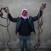 A man shows two ropes tied in the shape of nooses, found in the infamous Saydnaya military prison, just north of Damascus, Syria, December 9, 2024. (Hussein Malla/AP)
