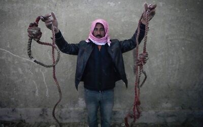 A man shows two ropes tied in the shape of nooses, found in the infamous Saydnaya military prison, just north of Damascus, Syria, December 9, 2024. (Hussein Malla/AP)