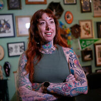 Tattoo artist Mischa Ostberg talks with a visitor at the Ghost Rose Tattoo parlor, November 3, 2025, in Ellsworth, Maine. (AP Photo/Robert F. Bukaty)