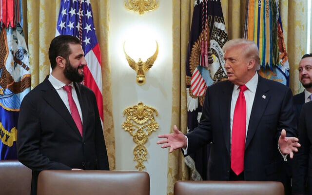 In this photo released by the Syrian Presidency press office, US President Donald Trump, right, speaks with Syria's President Ahmad al-Sharaa, at the White House in Washington, Nov. 10, 2025. (Syrian Presidency press office via AP)