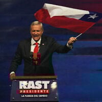 Presidential candidate Jose Antonio Kast of the Republican Party waves a flag during a campaign rally ahead of general elections, in Santiago, Chile, Nov. 11, 2025. (AP Photo/Esteban Felix)