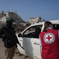 Illustrative: Hamas operatives accompanied by members of the International Committee of the Red Cross (ICRC) head to east of Gaza City to search for the bodies of hostages, November 13, 2025. (AP Photo/ Jehand Alshrafi)