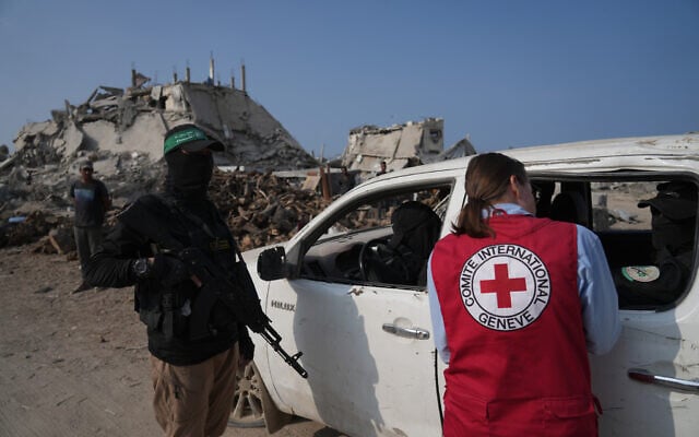 Illustrative: Hamas operatives accompanied by members of the International Committee of the Red Cross (ICRC) head to east of Gaza City to search for the bodies of hostages, November 13, 2025. (AP Photo/ Jehand Alshrafi)