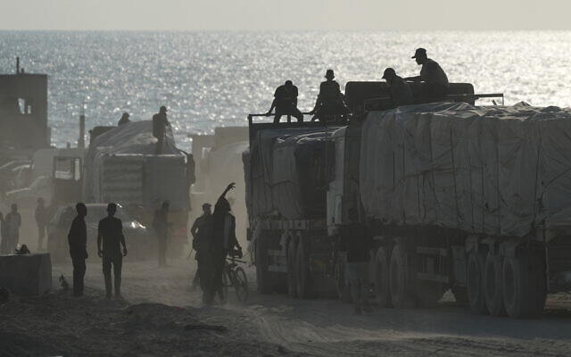 Trucks carrying commercial goods drive through Gaza City after entering from Israel via the Zikim crossing, in the northern Gaza Strip, November 13, 2025. (AP/Jehad Alshrafi)