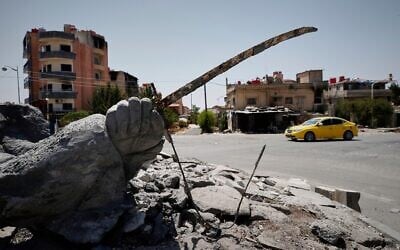Illustrative: A car drives by a destroyed statue in the Druze-majority town of Sweida, Syria, July 25, 2025. (AP Photo/Omar Sanadiki)