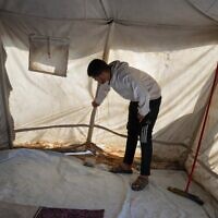 Muhannad Abu Muharib, 27, reinforces his tent after it was damaged by the storm at a temporary camp on the beach in Deir al-Balah, in the central Gaza Strip, November 15, 2025. (AP Photo/Abdel Kareem Hana)