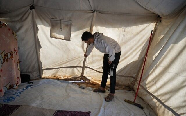 Muhannad Abu Muharib, 27, reinforces his tent after it was damaged by the storm at a temporary camp on the beach in Deir al-Balah, in the central Gaza Strip, November 15, 2025. (AP Photo/Abdel Kareem Hana)