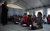 Palestinian students attend class inside a tent set up on the beach in Khan Younis, Gaza Strip, November 12, 2025. (AP Photo/Abdel Kareem Hana)