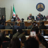 Suspects stand inside a holding cell, left, as judges preside over Syria's first public trial related to deadly clashes in March along the country's coastal provinces, at the Palace of Justice in Aleppo, Syria, Nov. 18, 2025. (AP Photo/Ghaith Alsayed)