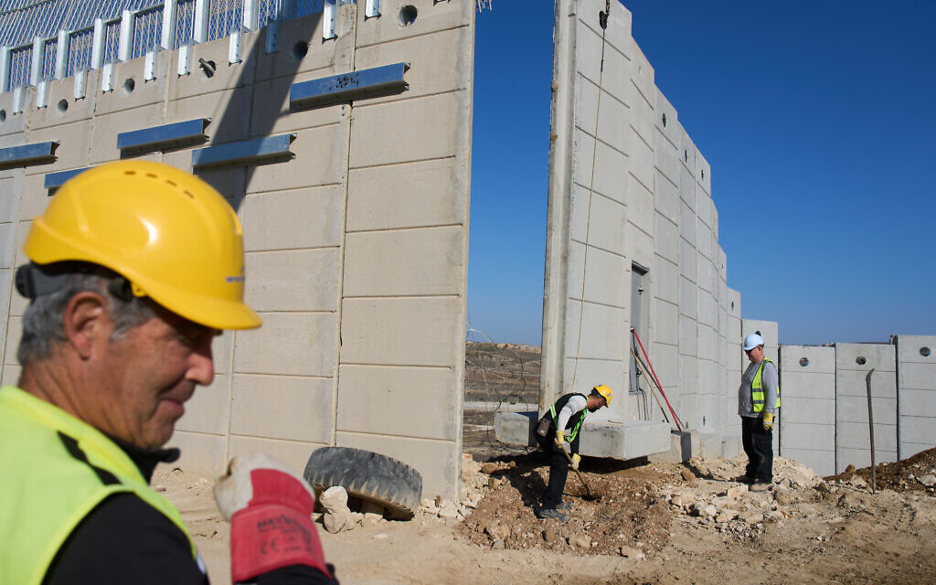 Construction workers build a wall along the border with Lebanon, in northern Israel, Wednesday, Nov. 19, 2025. (AP Photo/Ariel Schalit)