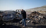 Mohammad Dalal looks at scorched cars in his scrapyard that was set ablaze the night before by people who local residents alleged were Israeli settlers in the town of Huwara near the West Bank city of Nablus, Friday, Nov. 21, 2025. (AP Photo/Nasser Nasser)