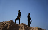 Islamic Jihad gunmen search for the bodies of hostages north of Nuseirat, Gaza Strip November 21, 2025. (AP/Abdel Kareem Hana)