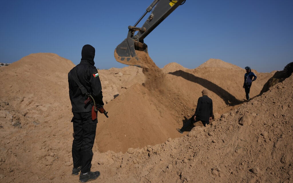 Islamic Jihad operatives and Egyptian workers search for the bodies of hostages north of Nuseirat, Gaza strip, Saturday, Nov. 22, 2025. (AP Photo/Abdel Kareem Hana)