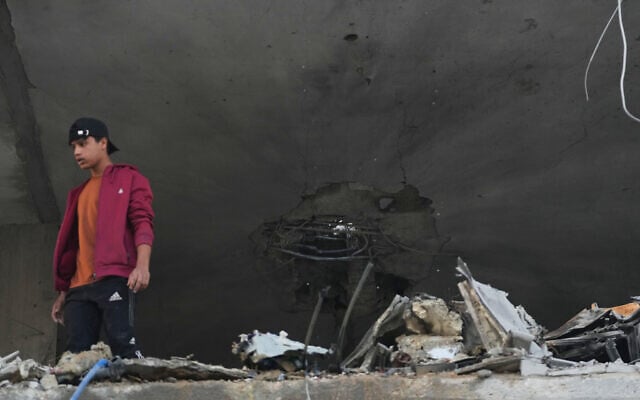 Palestinians inspect the damage to a house targeted by an Israeli strike in Deir al-Balah, in the central Gaza Strip, November 22, 2025. (AP Photo/Abdel Kareem Hana)