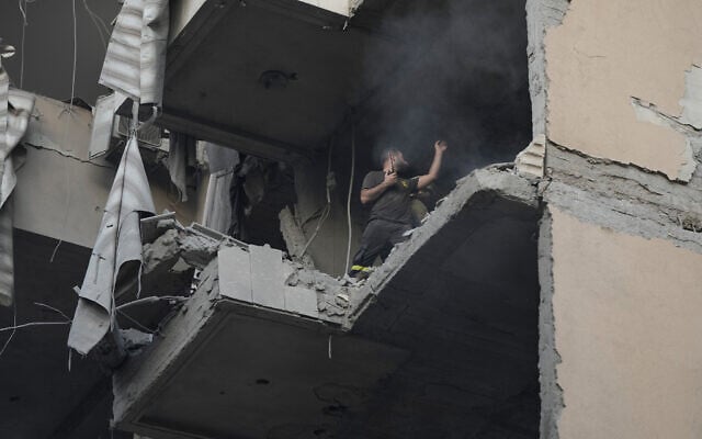 A civil defense worker inspects the damage at an apartment building hit during an Israeli airstrike in the southern suburb of Beirut, on November 23, 2025. (AP Photo/Bilal Hussein)