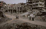 Palestinians walk among the ruins of destroyed buildings in Gaza City, Nov. 24, 2025. (AP Photo/Jehad Alshrafi)