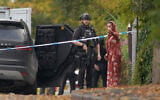 An armed police officer speaks to member of the public near the scene of terror attack at Heaton Park Hebrew Congregation synagogue, in Crumpsall, Manchester, England, on Yom Kippur, the holiest day of the Jewish year, October 2, 2025. (AP Photo/Ian Hodgson)