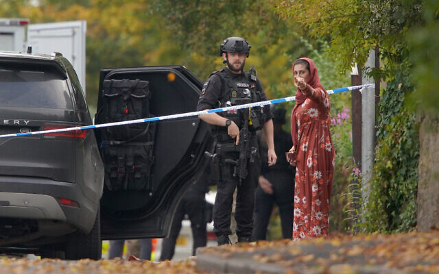 An armed police officer speaks to member of the public near the scene of terror attack at Heaton Park Hebrew Congregation synagogue, in Crumpsall, Manchester, England, on Yom Kippur, the holiest day of the Jewish year, October 2, 2025. (AP Photo/Ian Hodgson) An armed police officer speaks to member of the public near the scene of terror attack at Heaton Park Hebrew Congregation synagogue, in Crumpsall, Manchester, England, on Yom Kippur, the holiest day of the Jewish year, October 2, 2025. (AP Photo/Ian Hodgson)