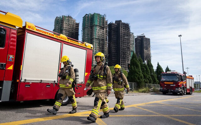 Firefighters walk past the scene after deadly fires at Wang Fuk Court, a residential estate in the Tai Po district of Hong Kong's New Territories, November 28, 2025. (AP Photo/Chan Long Hei) Firefighters walk past the scene after deadly fires at Wang Fuk Court, a residential estate in the Tai Po district of Hong Kong's New Territories, November 28, 2025. (AP Photo/Chan Long Hei)