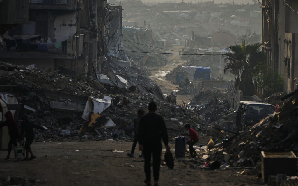 Palestinians walk through the destruction in Gaza City, November 29, 2025. (AP Photo/Abdel Kareem Hana) Palestinians walk through the destruction in Gaza City, November 29, 2025. (AP Photo/Abdel Kareem Hana)