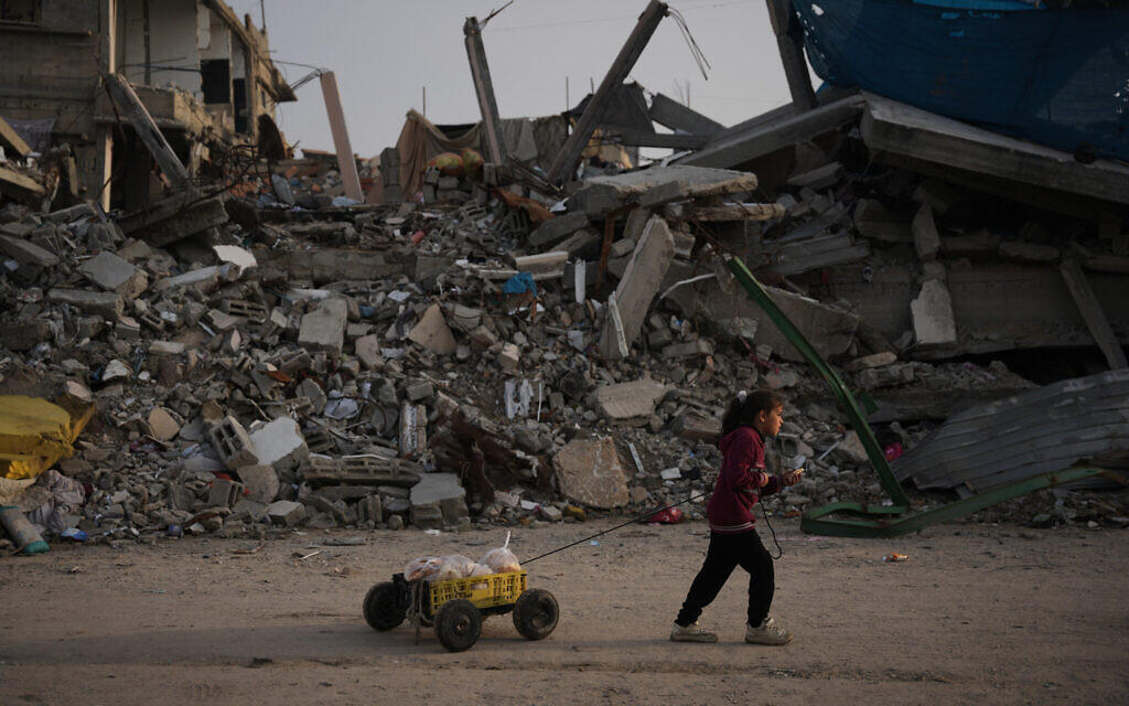 A girl carries bread as she walks past destruction left by Israeli air and ground operations in Gaza City, November 29, 2025. (AP Photo/Abdel Kareem Hana) A girl carries bread as she walks past destruction left by Israeli air and ground operations in Gaza City, November 29, 2025. (AP Photo/Abdel Kareem Hana)