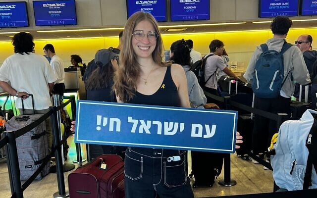 Columbia graduate Chloe Katz holds a sign reading, 'The Jewish nation lives on,' as she prepares to embark on her move to Israel, August 2025. (Courtesy) Columbia graduate Chloe Katz holds a sign reading, 'The Jewish nation lives on,' as she prepares to embark on her move to Israel, August 2025. (Courtesy)