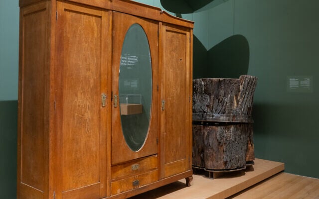 A wardrobe pierced by a bayonet (with a hole in the upper right), and a tree trunk that a young man hid in to escape the Nazis are two of the artifacts displayed in Yad Vashem's Living Memory exhibition (Yad Vashem)