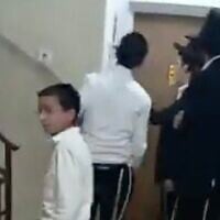 Haredi extremists chant "Traitor" and bang on the door of Shas MK Yinon Azoulay's apartment in Ashdod, November 19, 2025. (X screenshot)