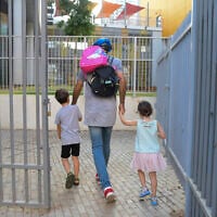 Illustrative: Parents accompany their children to the kindergarten in Tel Aviv on October18, 2020. (Avshalom Sassoni/Flash90)